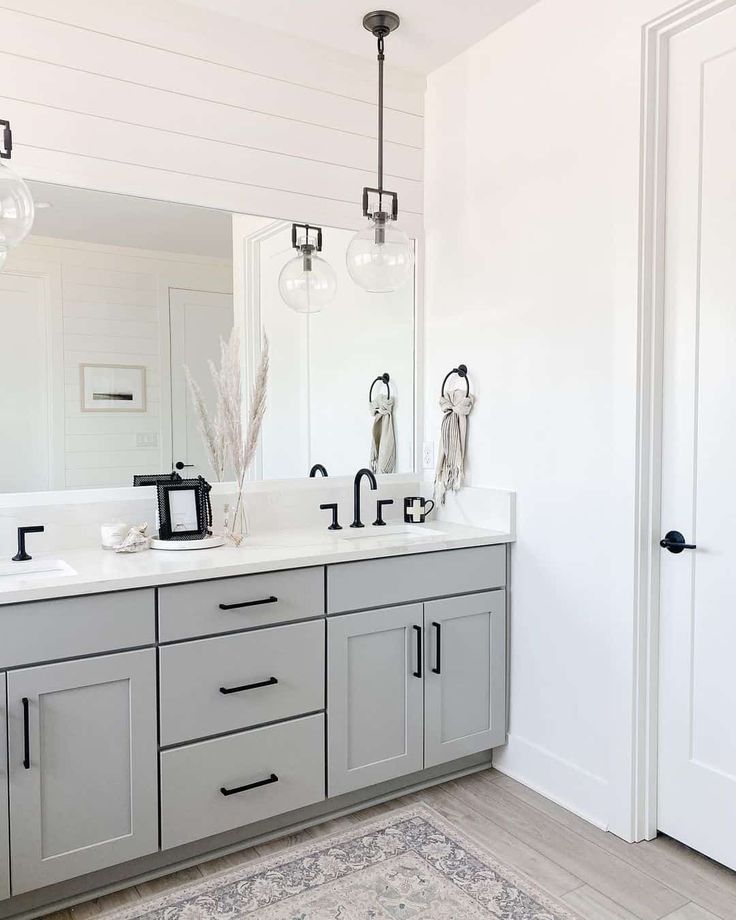 a bathroom with two sinks, mirrors and lights on the wall next to each other