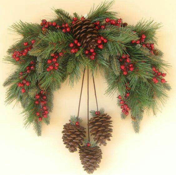 a christmas wreath with pine cones and berries