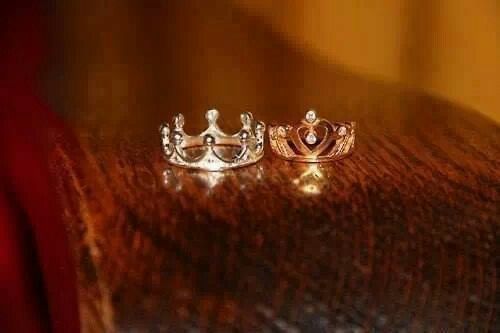 two silver crowns sitting on top of a wooden table