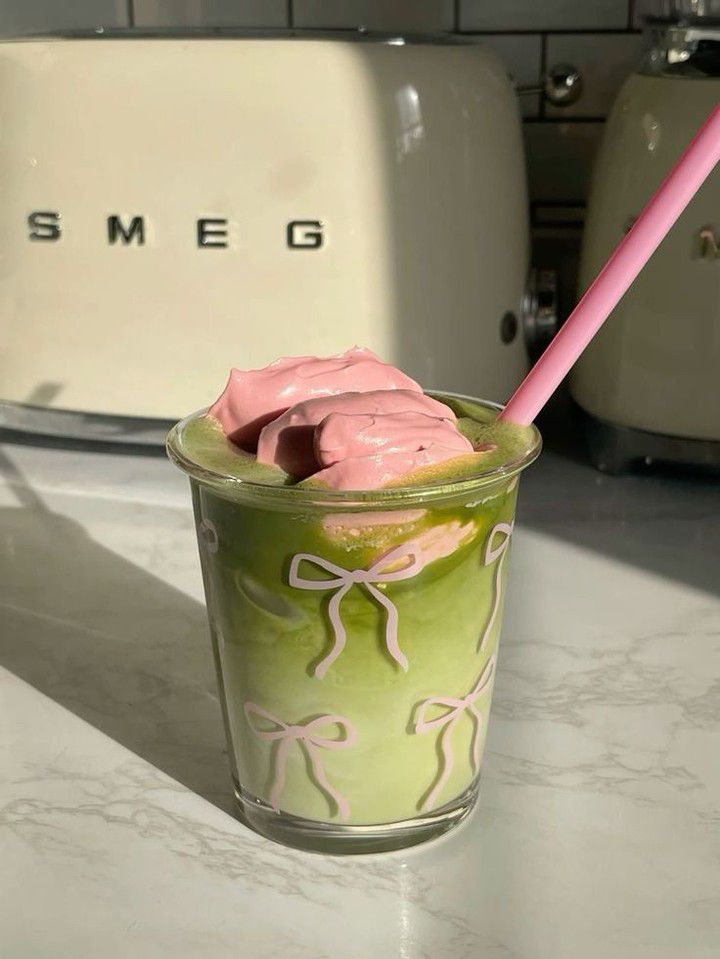 a green and pink drink sitting on top of a counter