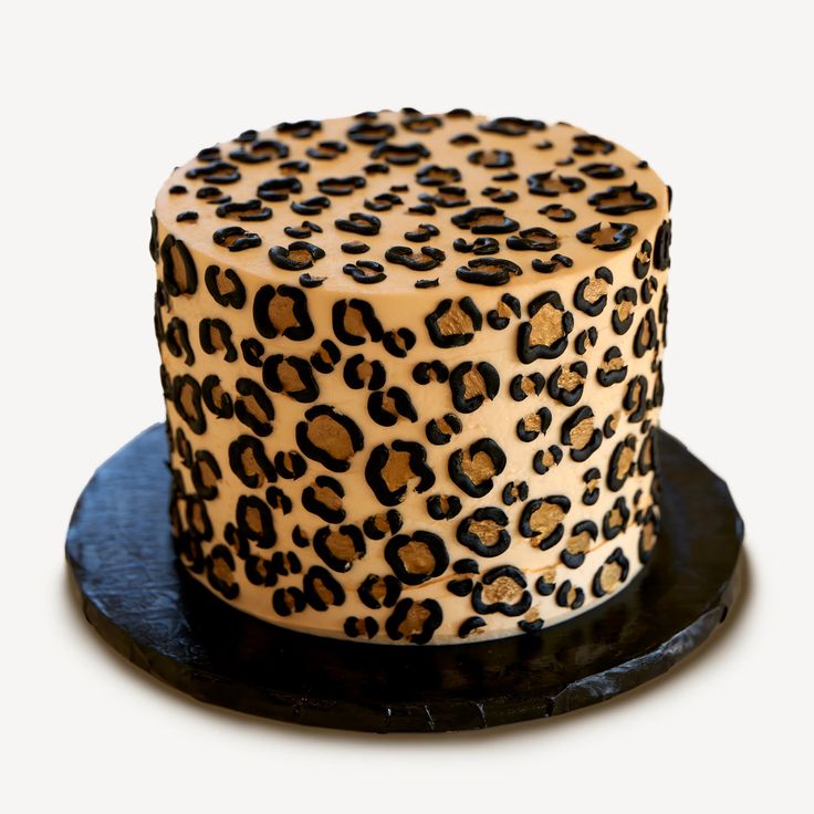 a leopard print cake sitting on top of a black plate