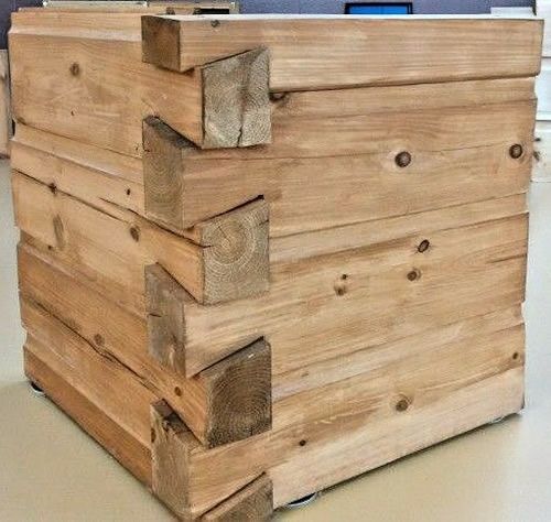 a stack of wooden crates sitting on top of a floor next to a computer desk