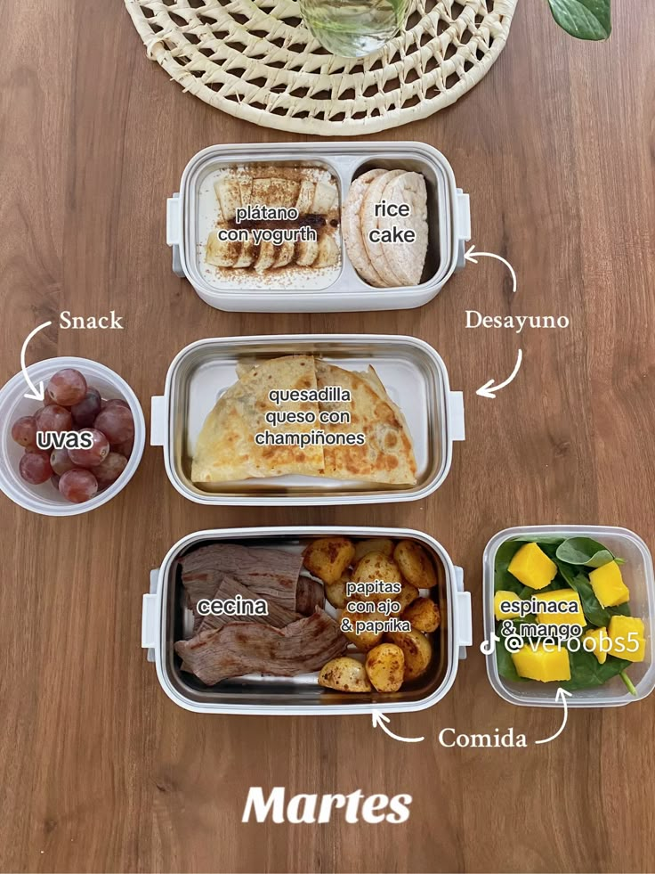 four containers with different foods in them on a wooden table next to a vase filled with flowers