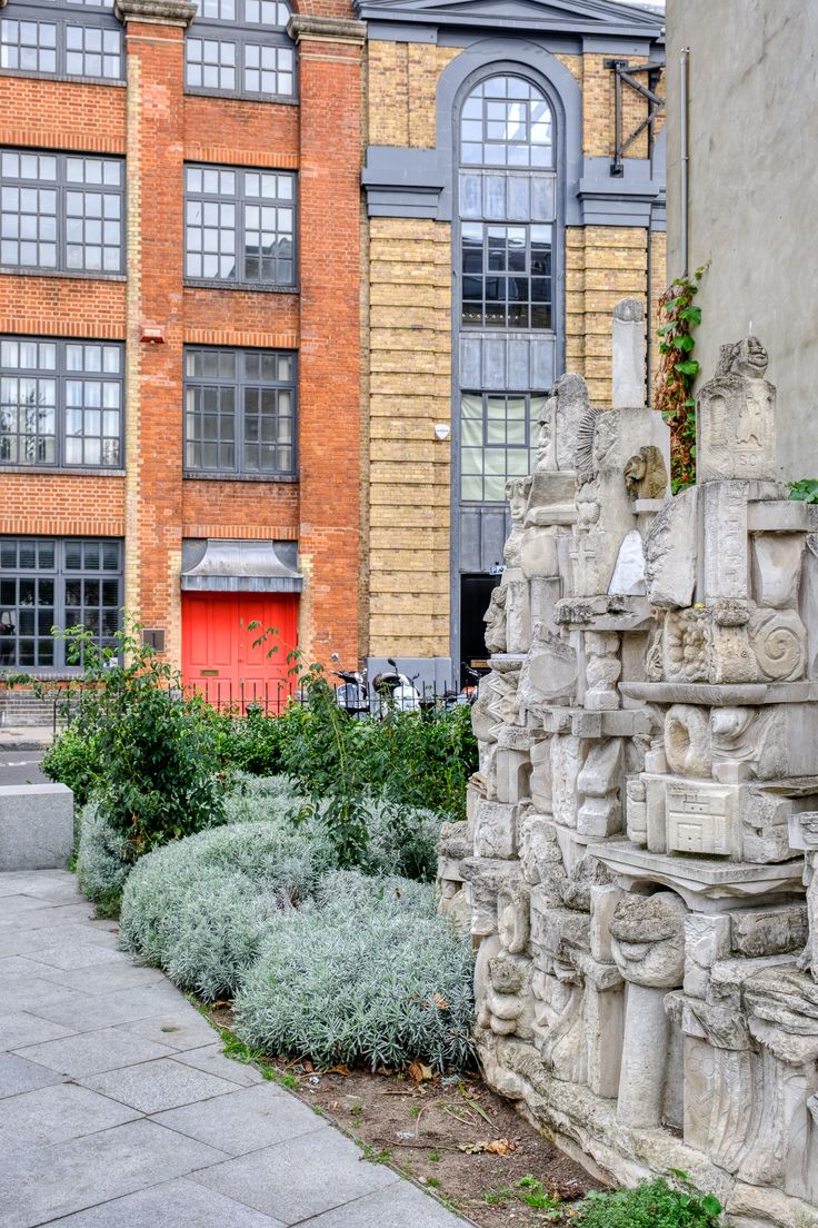 the building is made of brick and has many plants growing out of it's sides