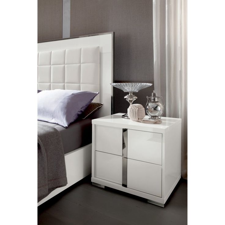 a white bed sitting next to a night stand