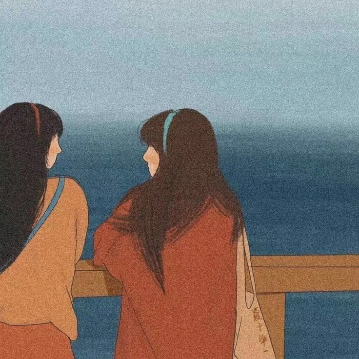 two women sitting on a bench looking out at the ocean