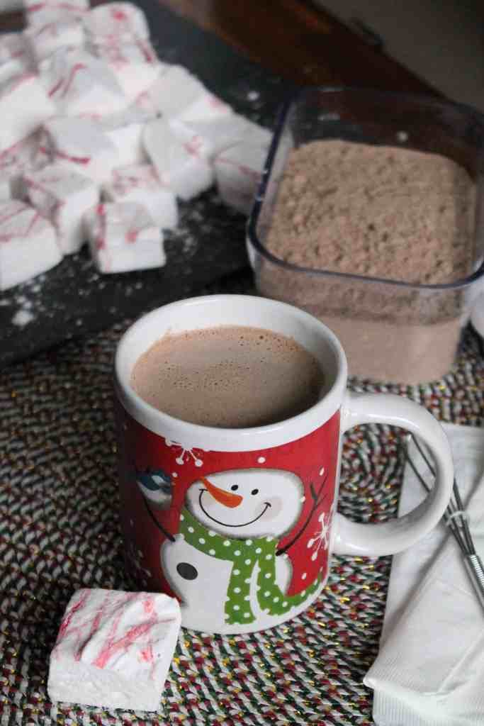 a cup of hot chocolate and marshmallows on a table with other items