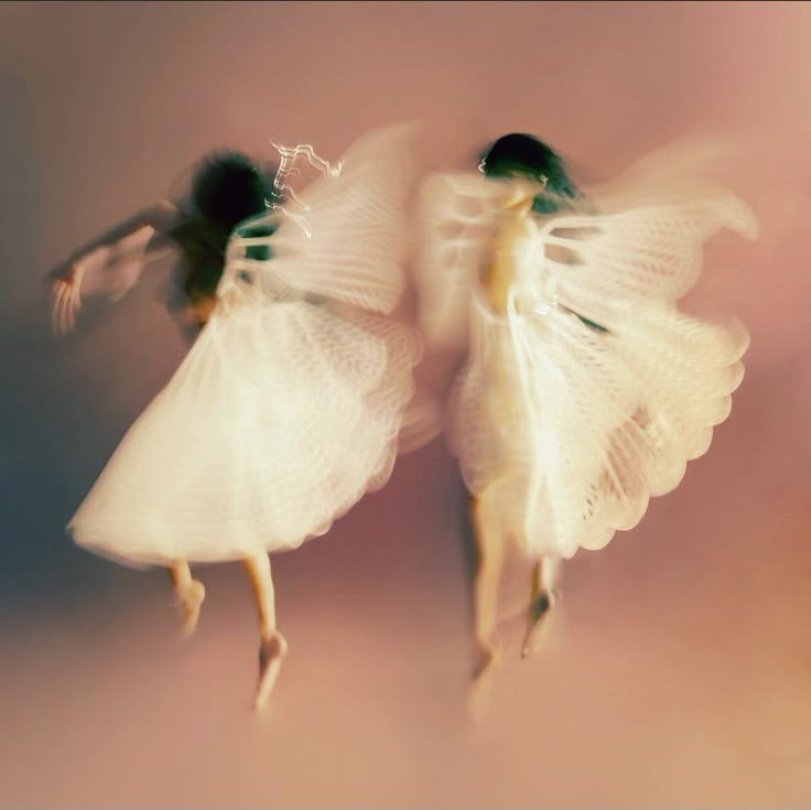 two white angel figurines flying in the air