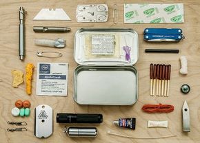 the contents of a travel kit laid out on a wooden table with pens, scissors and other items