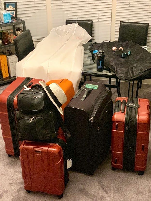 several pieces of luggage sitting on the floor in front of a dining room table and chairs