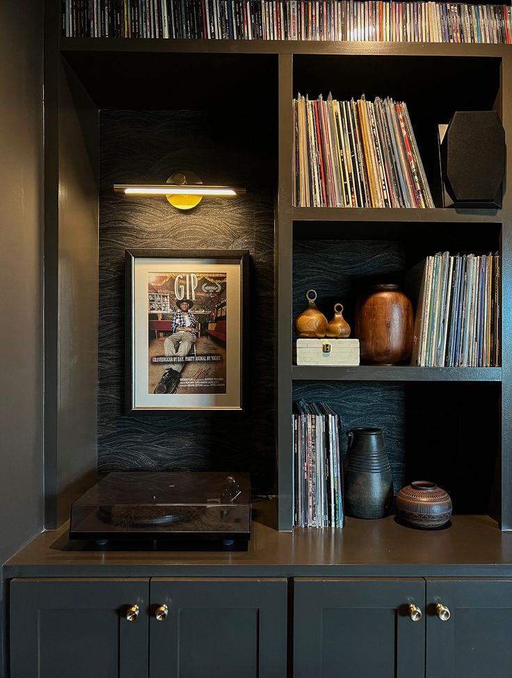 an entertainment center with record players and bookshelves