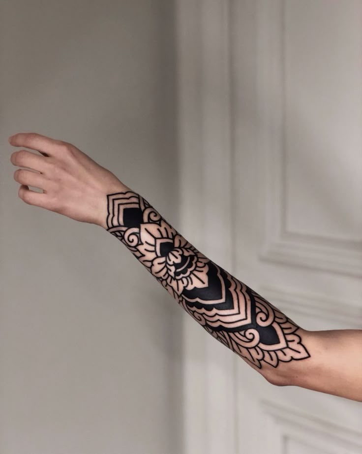 a person's arm with a tattoo on it and an intricate design in the middle