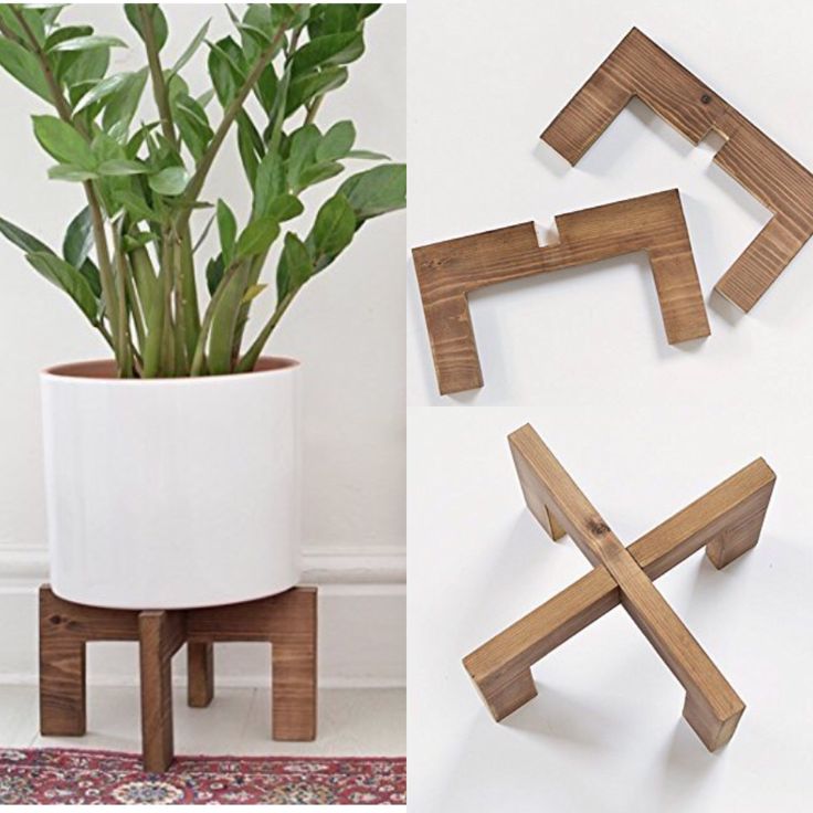 three wooden pieces are placed next to a plant in a white vase and another piece is made out of wood