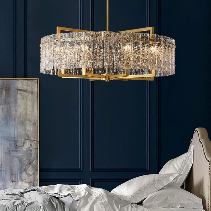 a chandelier hanging over a bed in a room with blue walls and white sheets