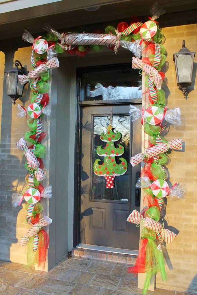 the front door is decorated for christmas with candy canes and bows on it's sides