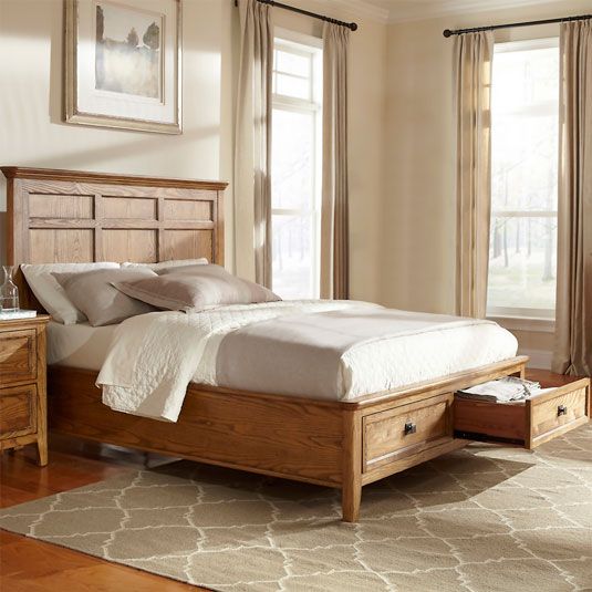 a wooden bed frame with drawers underneath it