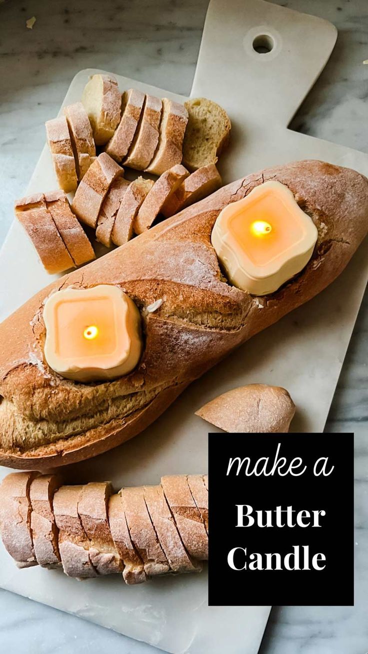 a loaf of bread sitting on top of a cutting board with candles in the middle