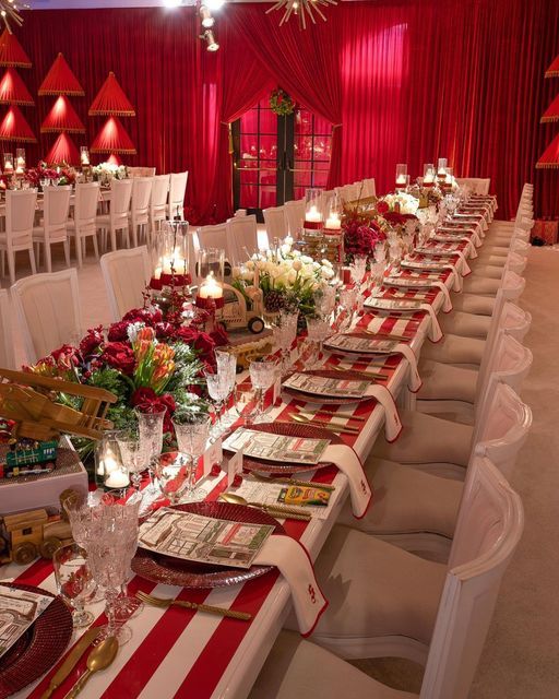 an image of a table set up for a formal event with red and white decor