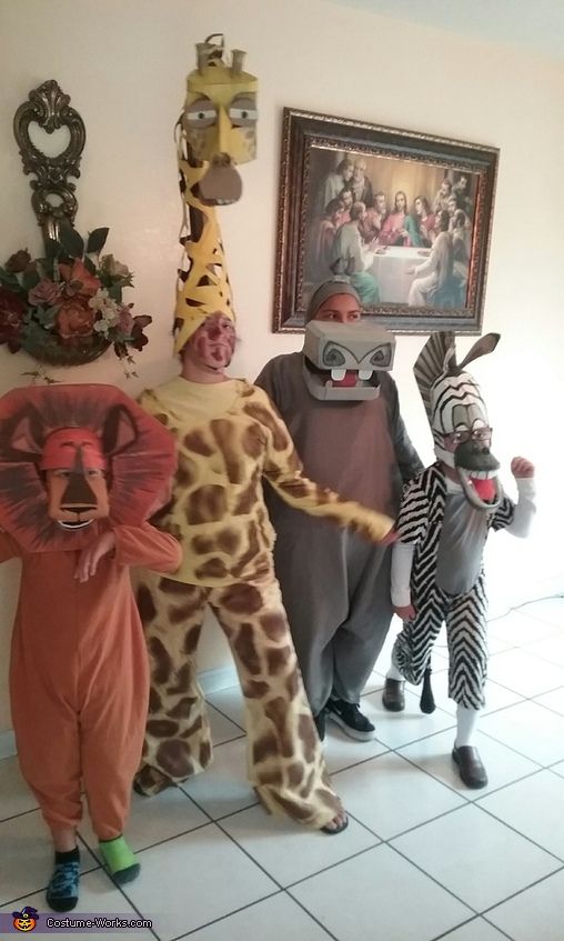 three people in animal costumes standing next to each other on tiled floored room floor