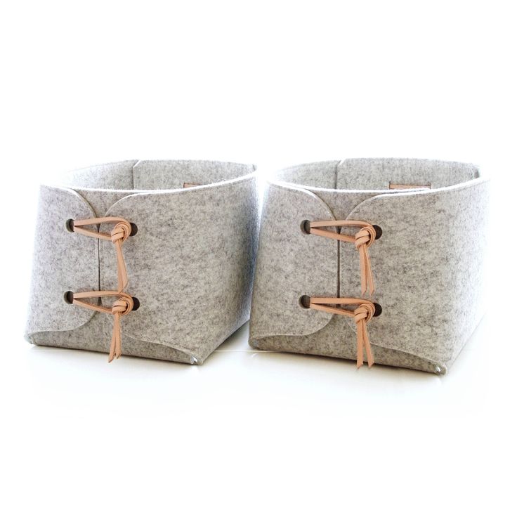 two gray baskets with handles on each side, one is made out of felt and the other has copper wire