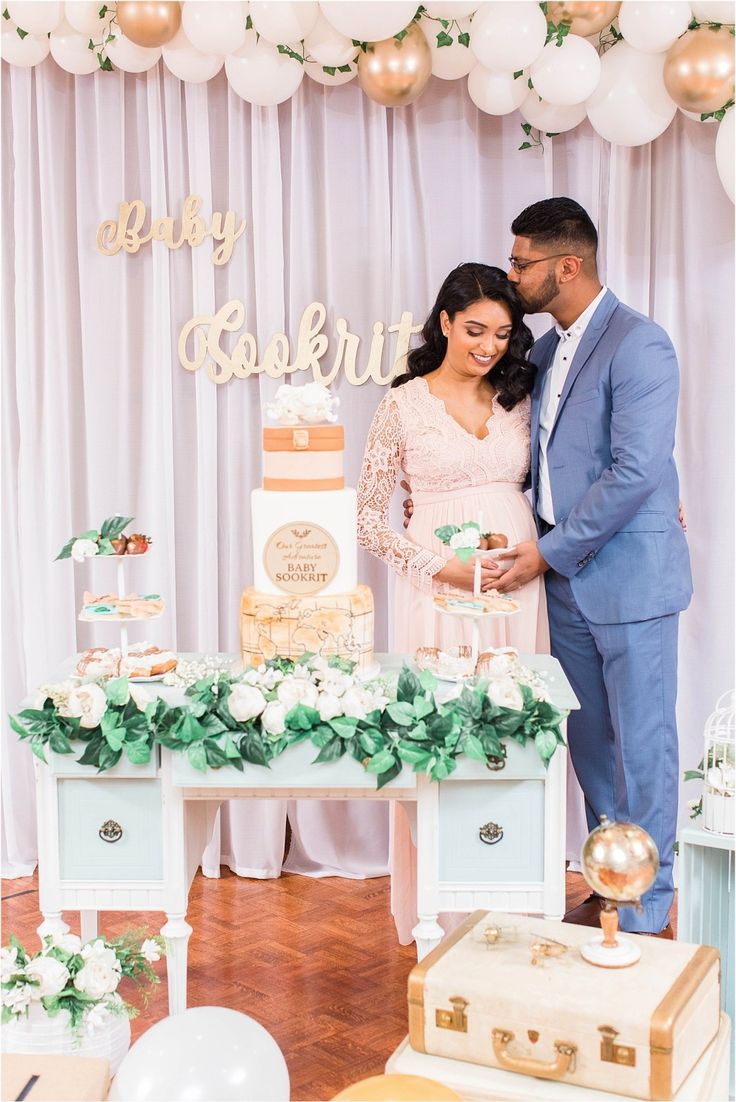 a man and woman standing in front of a table with a cake on top of it