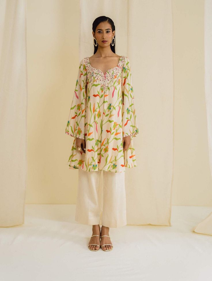 Editor's Note Featuring a cream kurta in dupion silk base with floral prints and bell sleeves. Paired with straight cropped pant. Fabric: Dupion silk, lining: crepe Color: Cream Neckline: Round with notch Sleeves: Full Fit: Relaxed Embroidery details: Hand embroidery Component: Kurta and pant Occasion: Daywear Care: Dry Clean Only About the Designer Drishti & Zahabia is all about contemporary styles and clean cuts with an Indian touch. Keeping it Elegant yet stylish and edgy, this designer duo a Bell Sleeves Kurti, Kurta Styling, Sleeves Design For Kurtis, Fashion Study, Kurti Design, Dupion Silk, Study Style, Embroidery Details, Kurti Designs