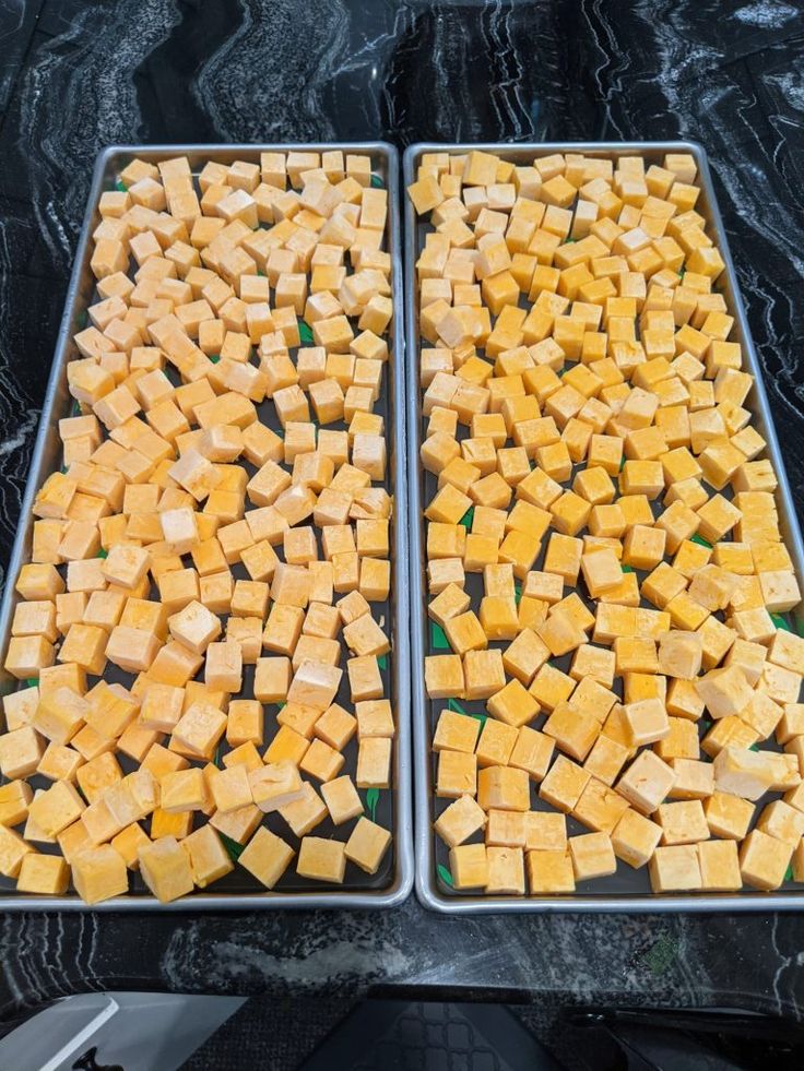 two pans filled with cheese sitting on top of a black counter next to each other