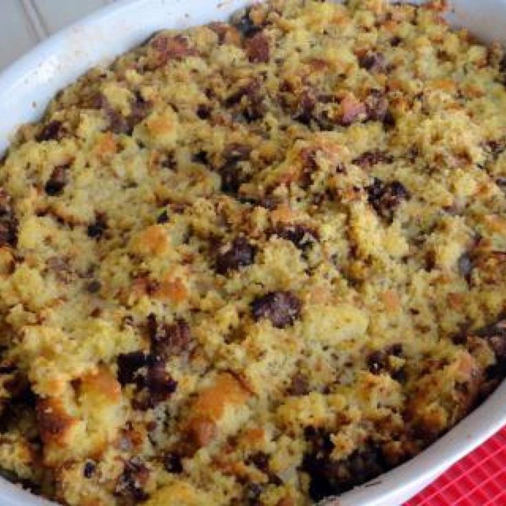 a casserole dish filled with lots of food on top of a red table