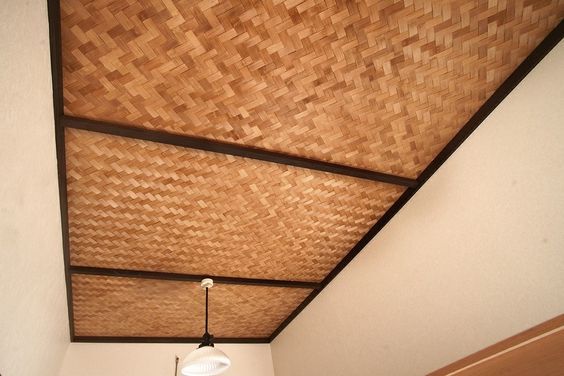 a room with a ceiling made out of woven material and a light fixture hanging from the ceiling