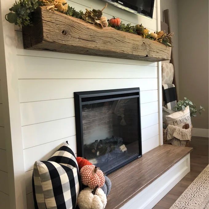 a living room with a fire place and television above the mantel in front of it