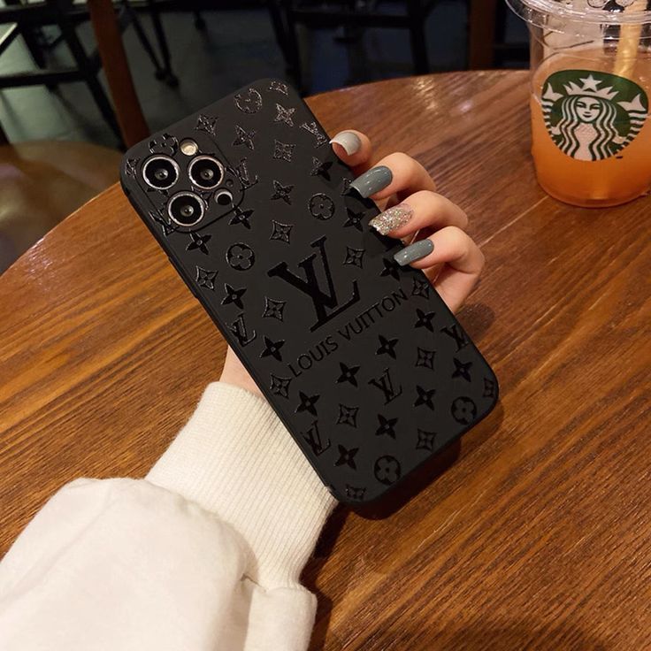 a woman's hand holding up a black phone case