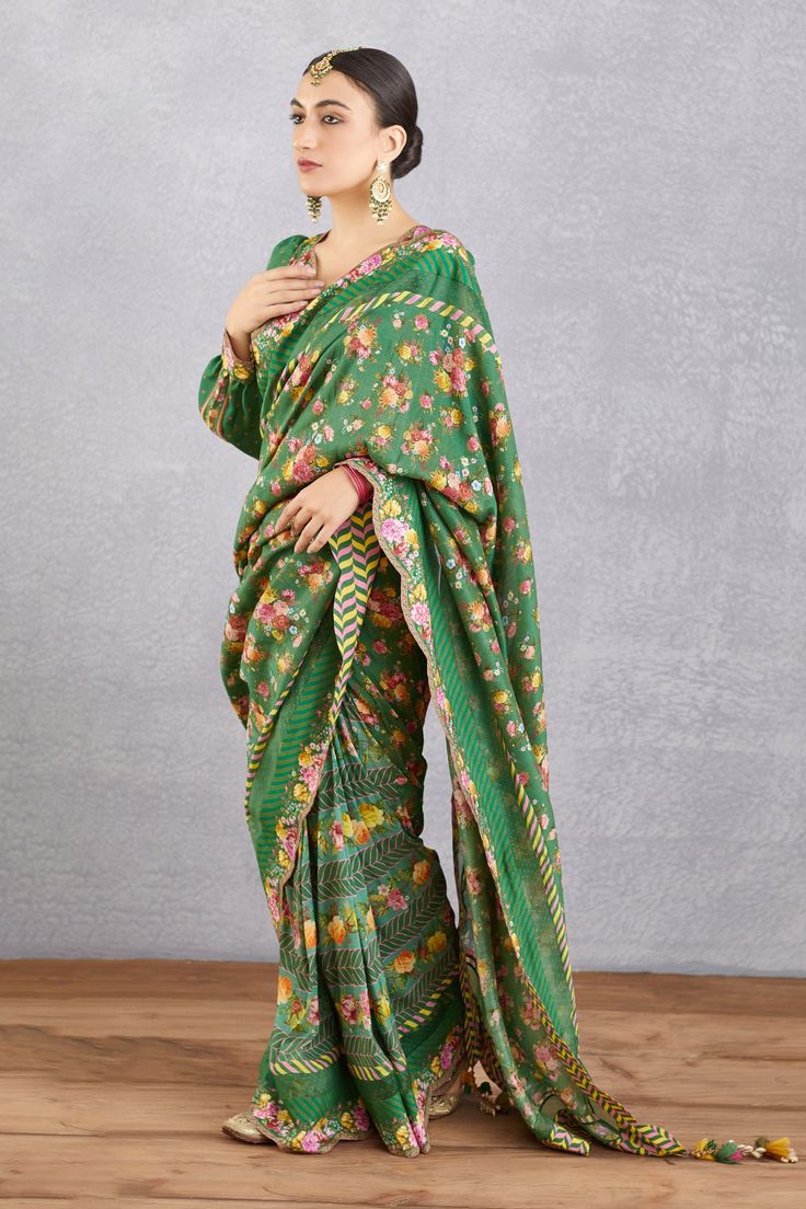 Emerald green saree blouse with all-over floral motifs, cutwork detail, tassel tie-ups and plunging neck.
Component: 1
Printed
Neckline: V Neck
Sleeve Length: Long
Fabric: Handwoven Chanderi, cotton silk
Color: Green
Plunging neck
Cutwork detail
Cuff sleeves
Note: Saree worn by the model is not for sale
 - Aza Fashions Emerald Green Saree, Emerald Green Blouse, Saree Blouses Online, Saree For Women, Green Saree, Blouse For Women, Silk Organza, Blouse Online, Printed Sarees