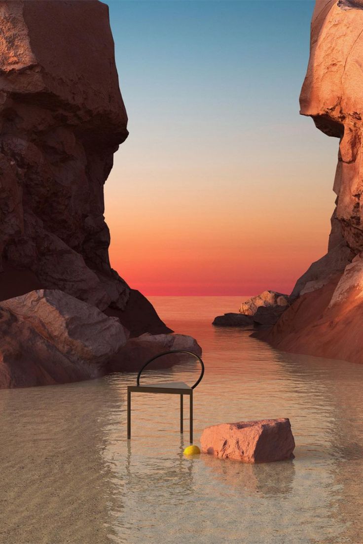 there is a chair sitting in the water next to some rocks and an orange ball