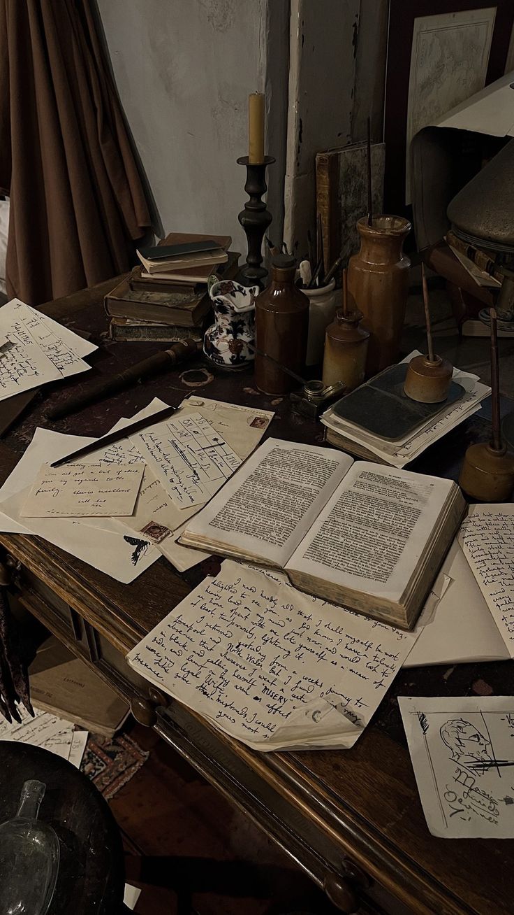 an old desk covered with lots of papers and writing on top of it, next to a lamp