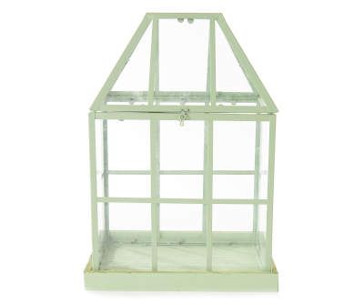 a small green glass house on a white background