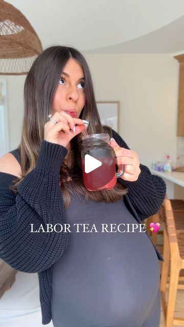 a pregnant woman drinking tea from a jar