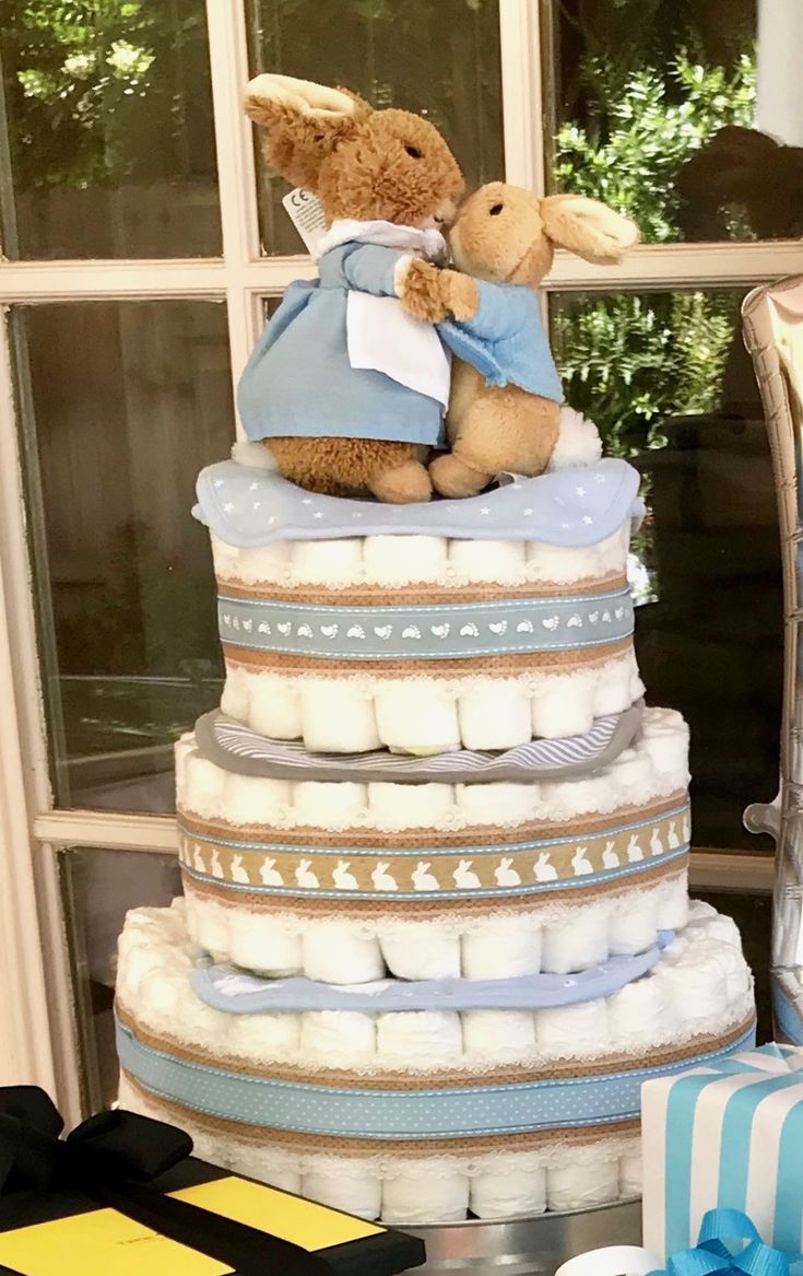 a teddy bear sitting on top of a stack of diapers next to a window