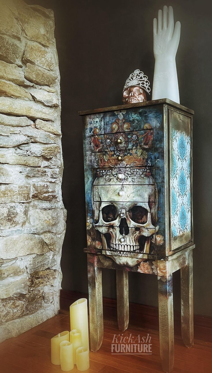 a skull on top of a cabinet next to candles