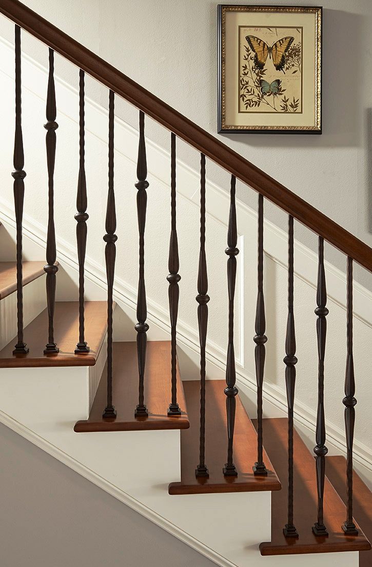 a stair case with wooden handrails and rails next to a painting on the wall