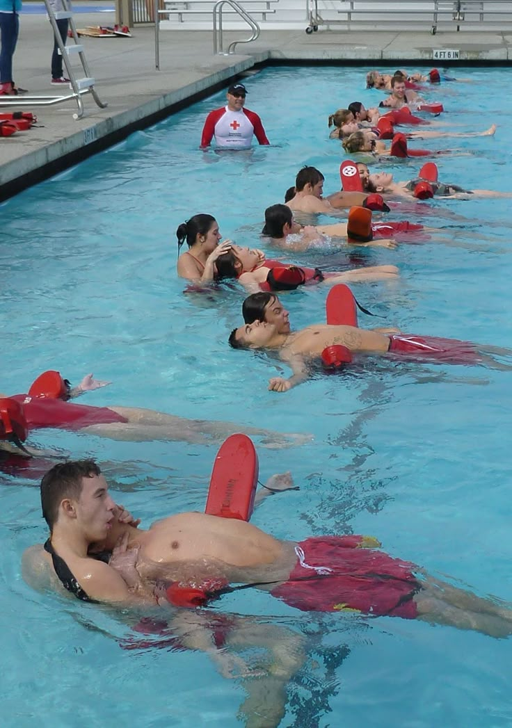 many people are swimming in the pool with life vests around their necks and feet