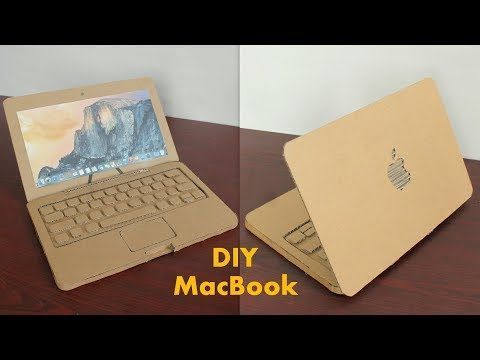 an open laptop computer sitting on top of a wooden table next to a cardboard box