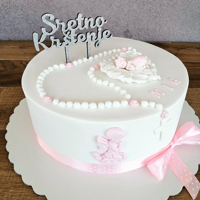 a white cake with pink decorations and a name sign on top that says strongo kreae