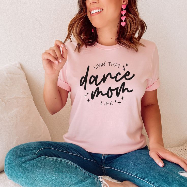 Dance mamas, we made the perfect shirt for watching your little dancer in class, dress rehearsal or a performance! Our dance mom life tee is available in pink and ash, and is soooo cute to match our dance your heart out tee for the littles! This design is also available in a match tote bag to carry around dance shoes, extra water, snacks and maybe a hairbrush for those ballet buns?? DETAILS Unisex sizing - aka mens sizing. If you want a looser fit, we recommend ordering your normal size or one up for an oversized fit. If you prefer a more fitted style, size down one. Tee - 52/48 Airlume combed and ringspun cotton/polyester. Side seams, shoulder to shoulder taping, tearaway label. Pink or Ash tee with black print Ballet Buns, Ballet Bun, Class Dress, Home Dance, Dress Rehearsal, Dance Mom, Rehearsal Dress, Fitted Style, Dance Moms