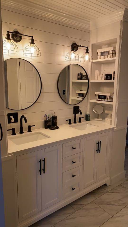 a bathroom with two sinks and mirrors on the wall