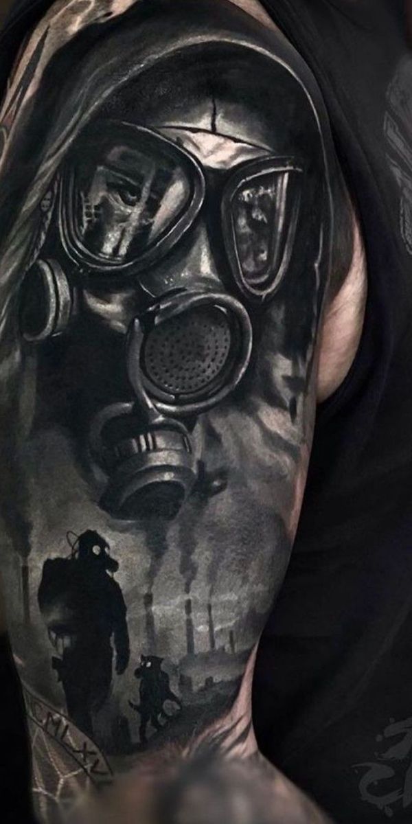 a man with a gas mask tattoo on his arm and shoulder is shown in black and grey