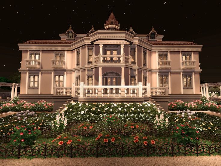 a large house with many windows and flowers in front of the building at night time