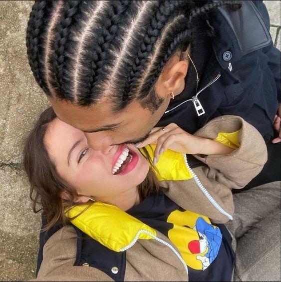 a man and woman with cornrows are smiling at each other while they both have their arms around one another