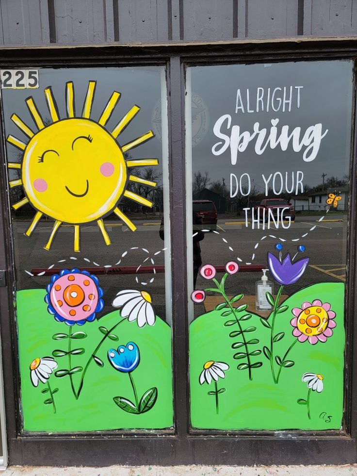 two windows painted with flowers and the words, alright spring do your thing