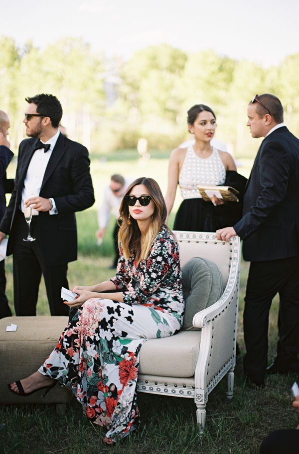 a woman sitting on top of a white chair next to other people in formal wear