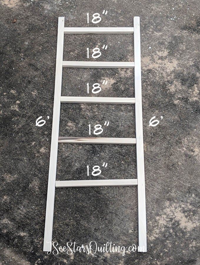 a white ladder sitting on top of a cement floor next to a measuring tape and numbers